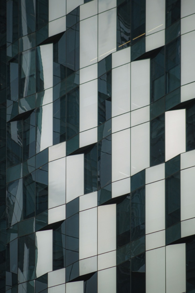 Offset glass and metal panels on a building facade, each set at a slightly different angle